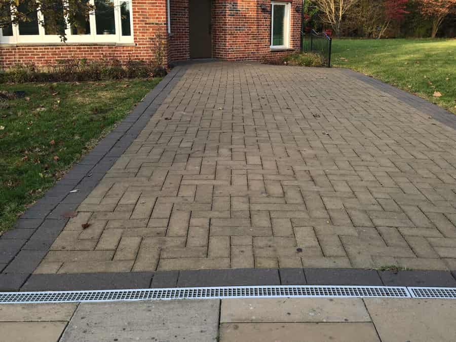 Finished block-paved driveway in Great Glen with a charcoal border and a new channel drain across the entrance